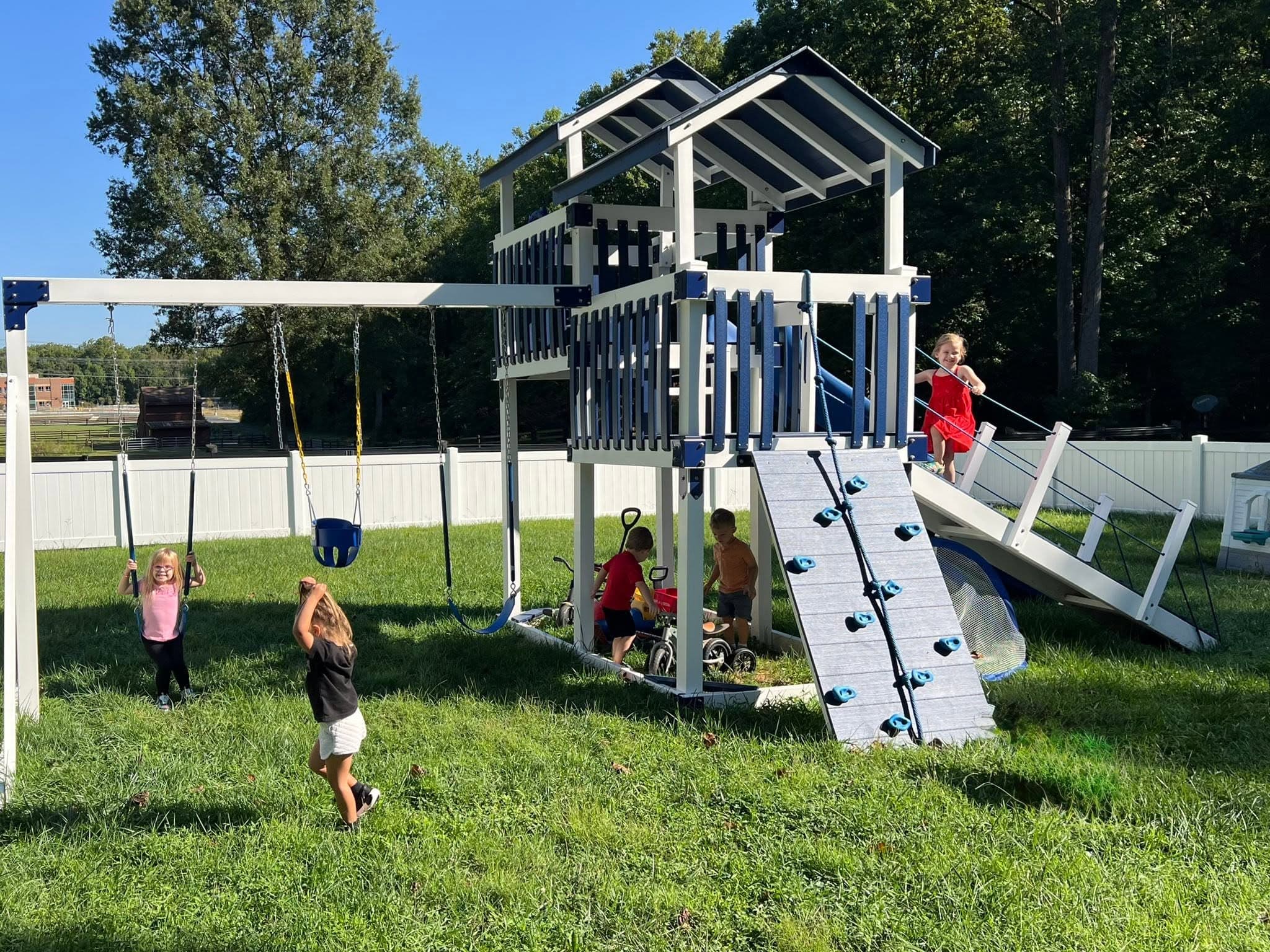 Children playing on the swing set and climbing frame at Little Ones Farm
